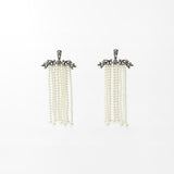 Pair of earrings with pearl-like beads on a white background