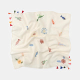 Embroidered blanket with colorful designs and tassels on a white background