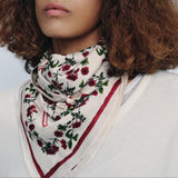Woman wearing a floral scarf with a plain background