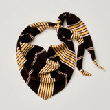 A striped knit bandana or scarf tied in a knot, featuring a black base with yellow and white stripes, laid flat on a light gray background.