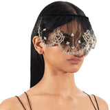 Woman wearing a decorative face mask and embellished dress on a white background