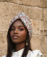 Woman wearing a decorative headband against a stone wall background