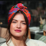 Woman wearing a colorful headscarf with a blurred background