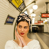 Woman wearing a patterned headscarf with a pink background