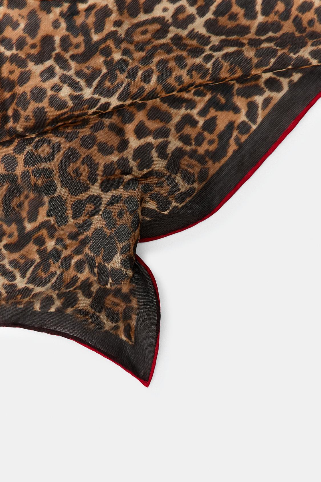 Leopard print scarf with a red border on a white background