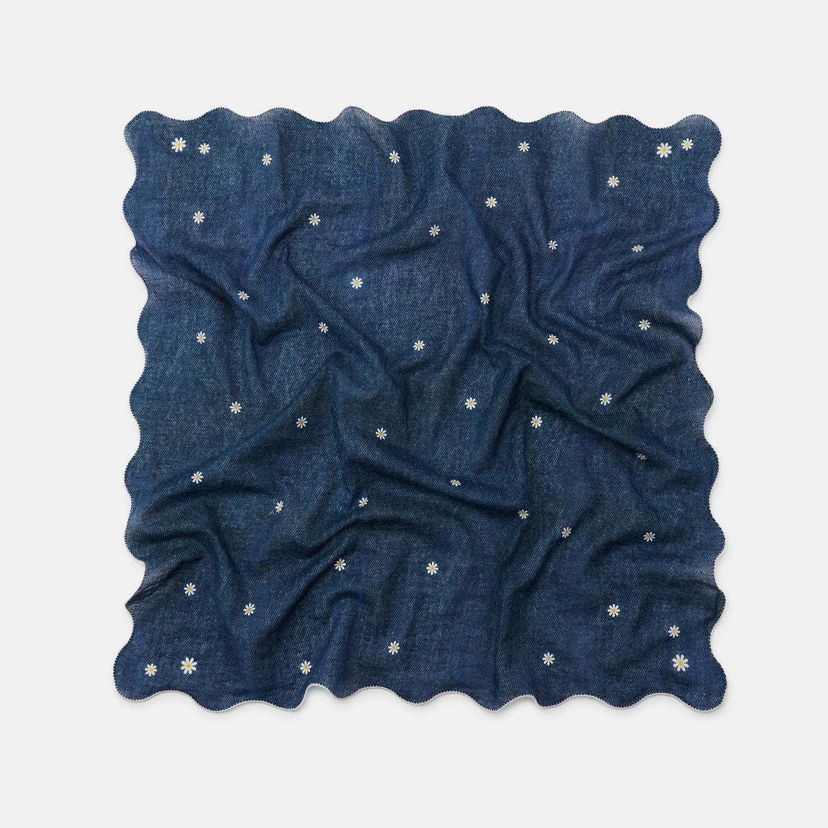 A square navy blue scarf with a wavy scalloped edge, featuring a scattered pattern of small white embroidered flowers, displayed on a light gray background.