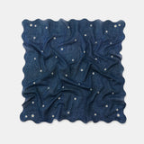 A square navy blue scarf with a wavy scalloped edge, featuring a scattered pattern of small white embroidered flowers, displayed on a light gray background.