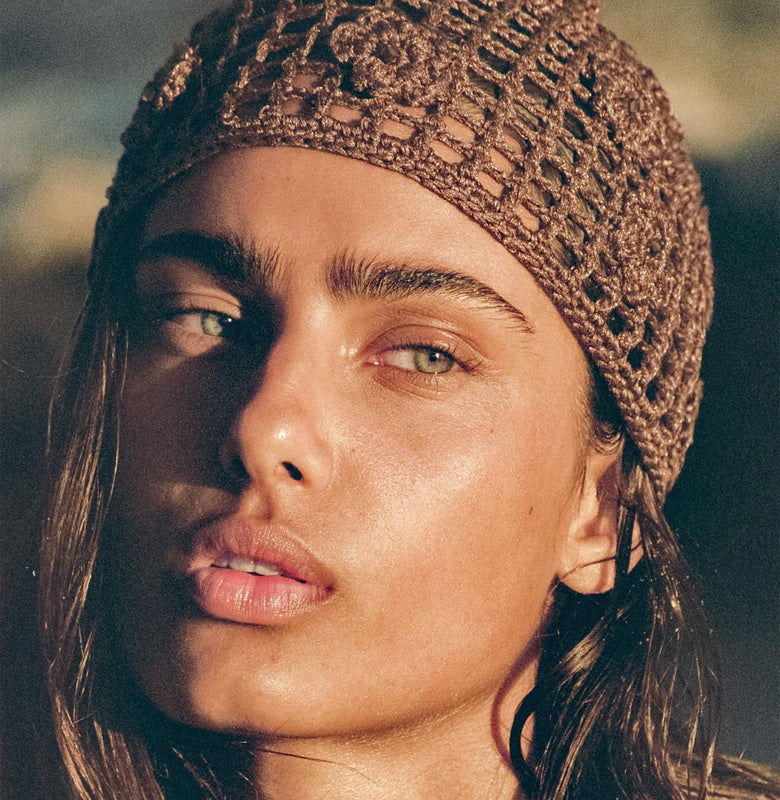 Woman wearing a brown knitted headband with a blurred background