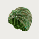 Green turban with sequins on a light gray background
