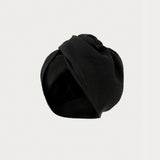 A black fabric headwrap or turban-style hair accessory, photographed against a plain light gray background.