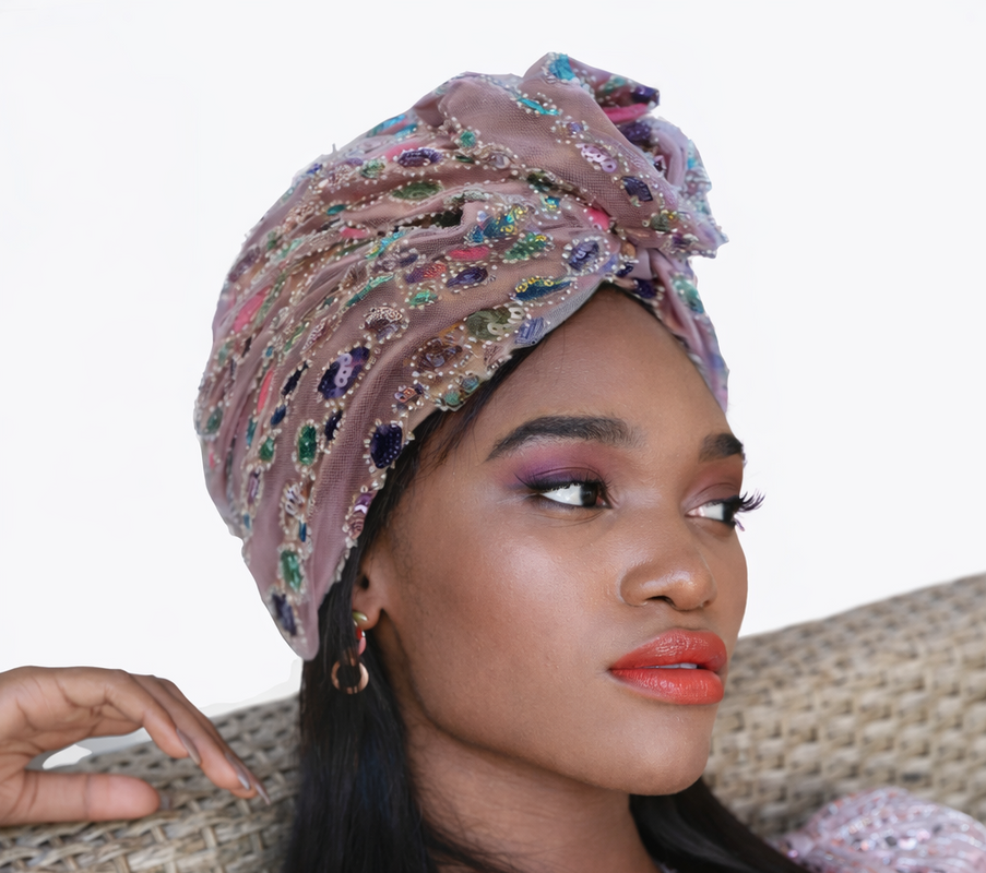 Woman wearing a patterned headscarf and sitting on a textured surface