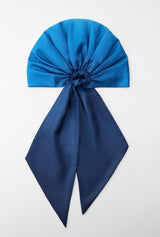 Blue satin hair bow on a light gray background