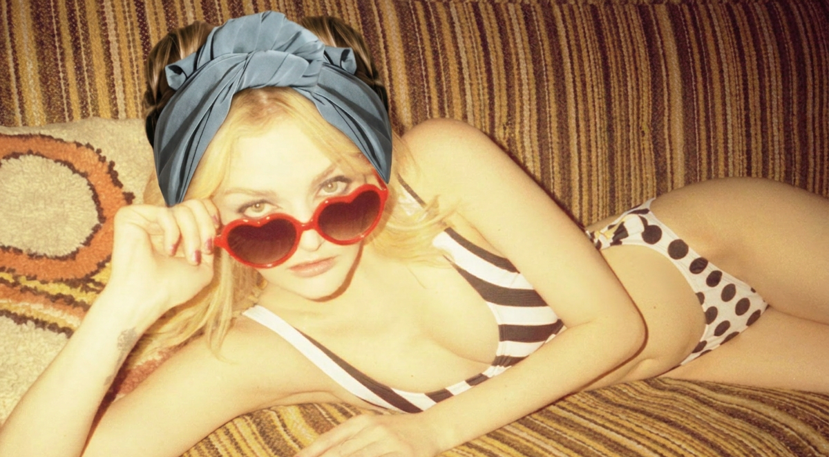 A woman reclining on a striped couch wearing a blue headwrap, a black-and-white striped bikini top, a black-and-white polka dot bikini bottom, and red heart-shaped sunglasses.