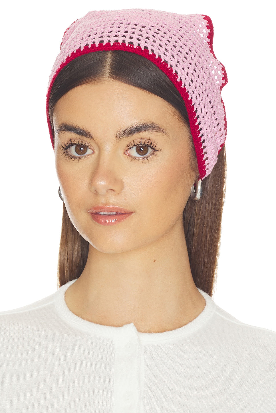 Woman wearing a pink knitted headband on a white background