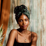 Woman wearing a green patterned headscarf with a blurred natural background