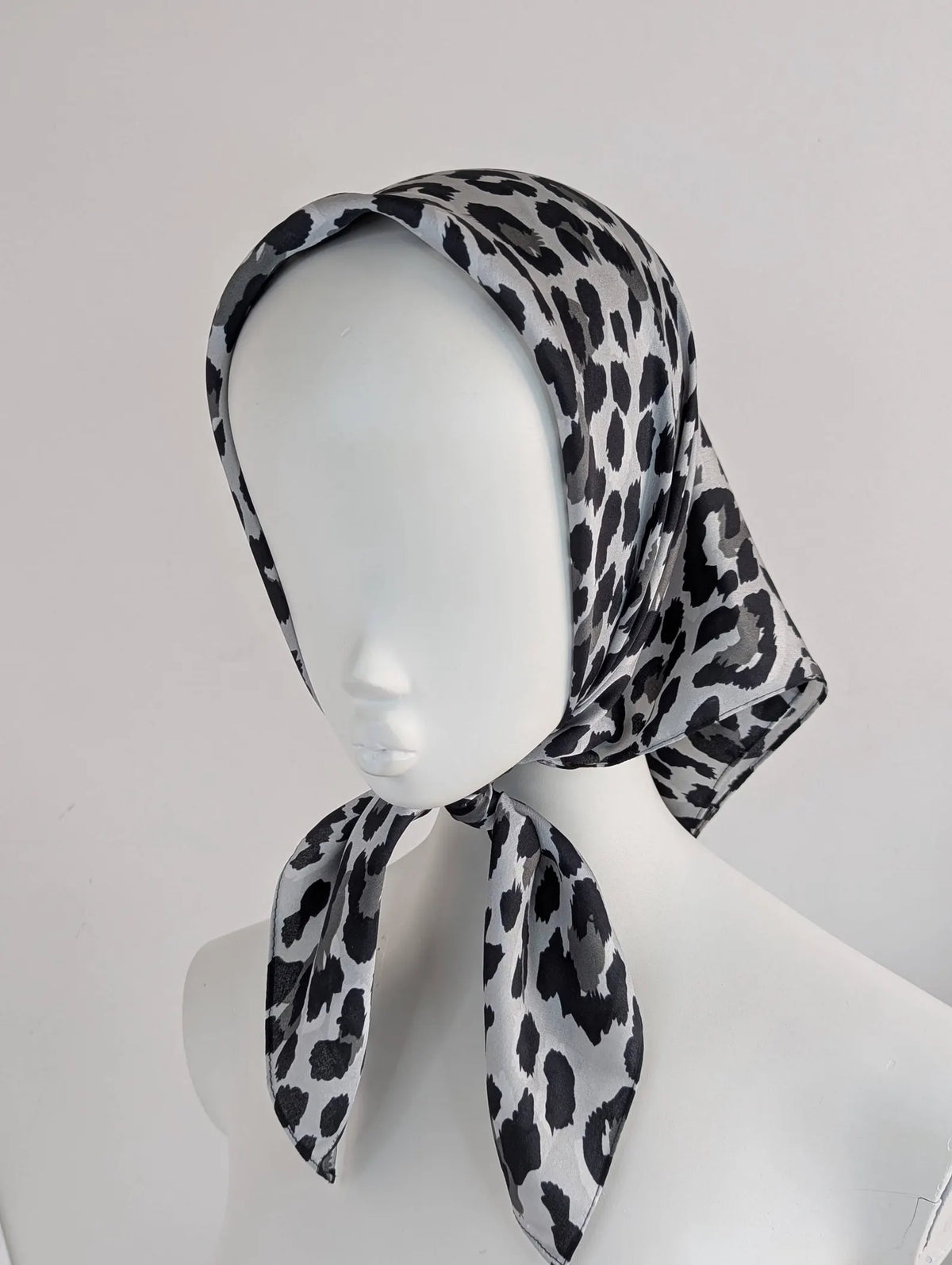 Leopard print headscarf on a mannequin head against a white background