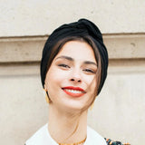 Woman wearing a floral blouse with a white collar against a neutral background